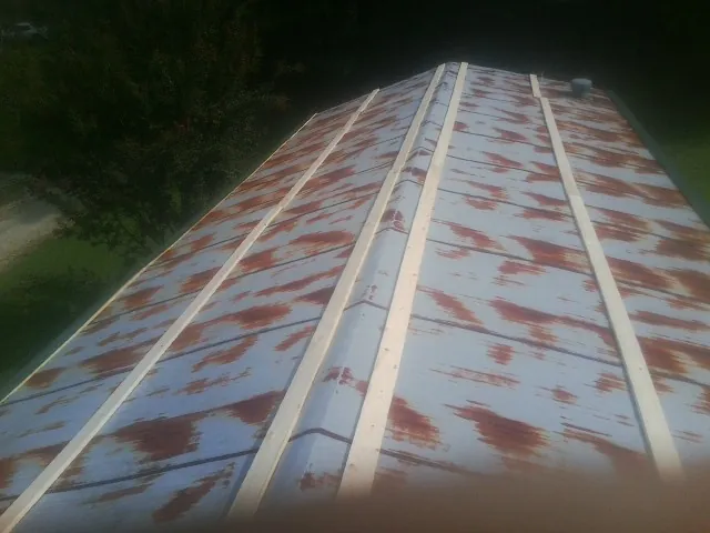 Rusted metal roof panels with new wood purlins before replacement — Storm Damage Roof Repair in Buies Creek by Roofing Brothers