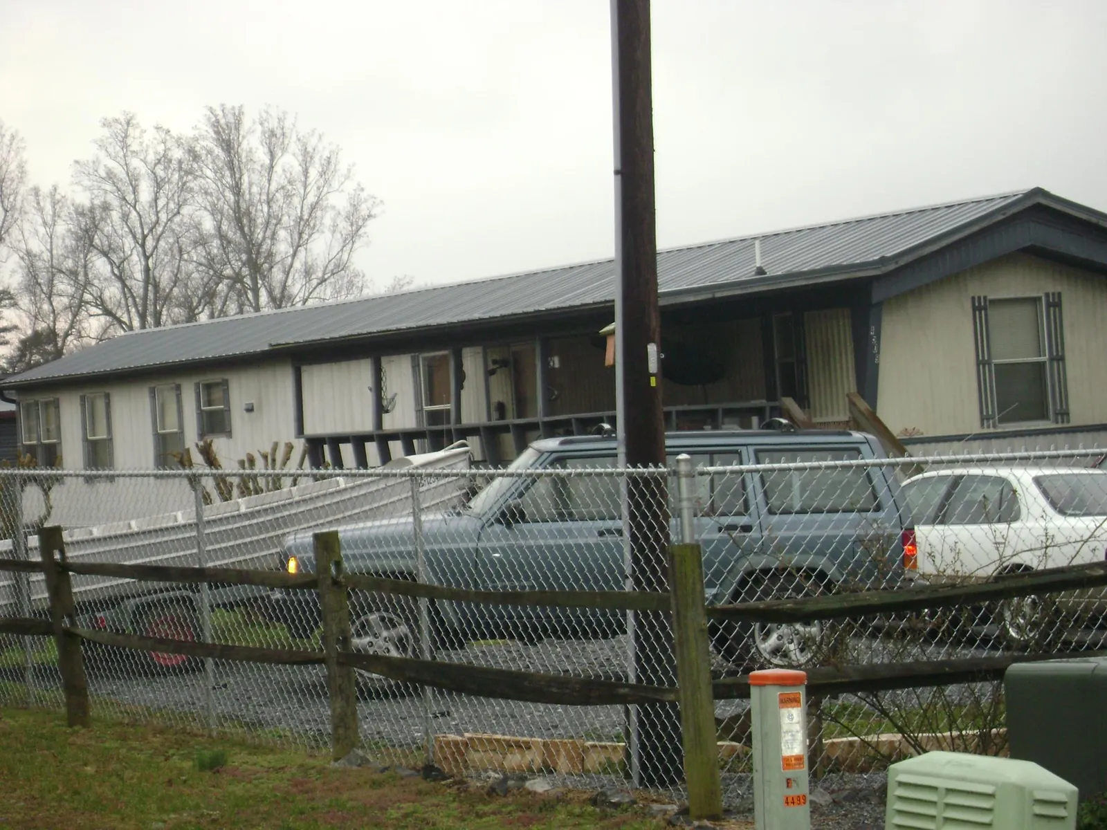 Dark metal roof on a long single story building behind a chain link fence in Buies Creek
