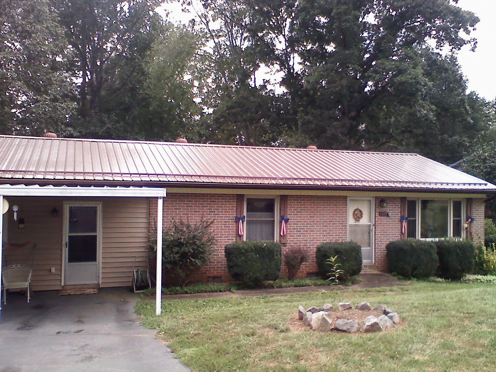 Bronze metal roof and carport on a brick ranch home — Roof Repair work by our crew in Buies Creek