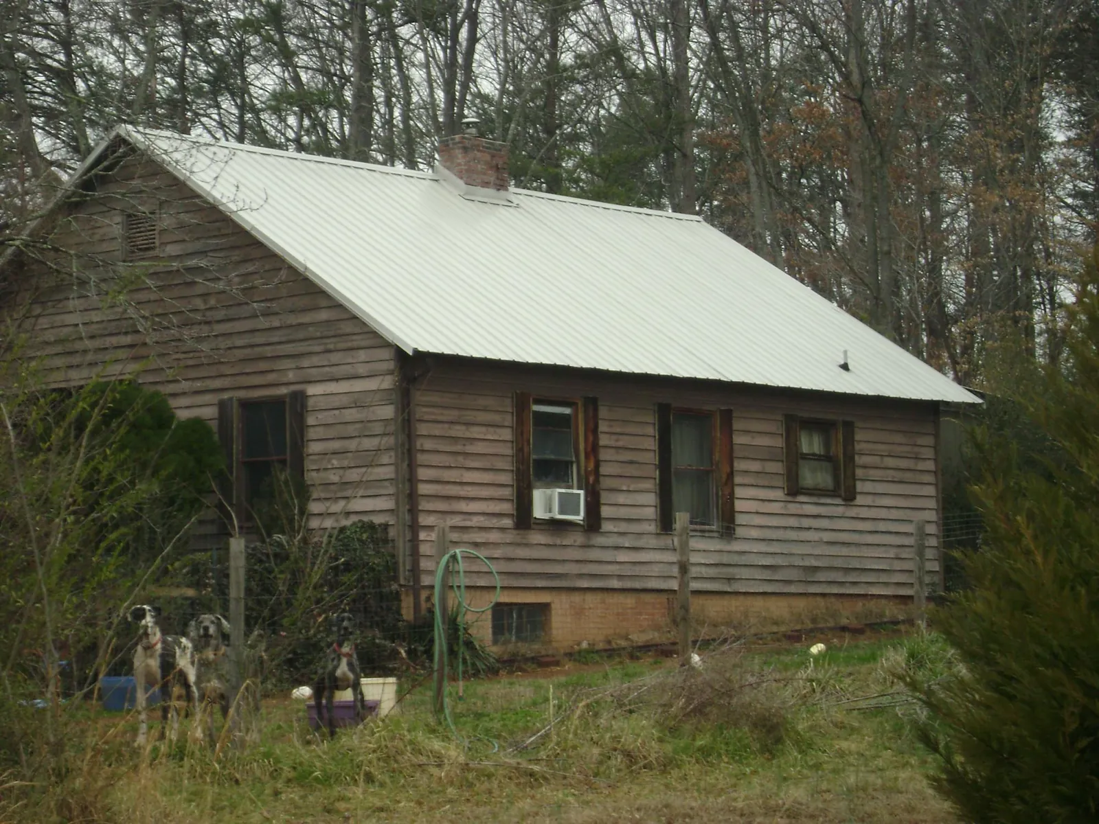 White metal roof on an old wood sided farmhouse, from a Metal Roof Installation job in Buies Creek